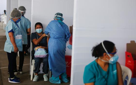 A health care worker receives a dose of Sinopharm's COVID-19 vaccine Feb. 9 in Lima, Peru. Peru's bishops denounced the giving of vaccines to VIPs instead of essential workers after the vaccine became available. (CNS/Reuters/Sebastian Castaneda)