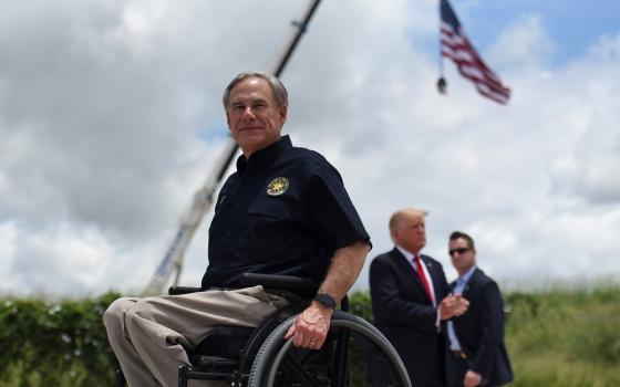 Texas Gov. Greg Abbott exits the stage with former President Donald Trump after a June 30 visit to an unfinished section of the wall along the U.S.-Mexico border in Pharr, Texas.