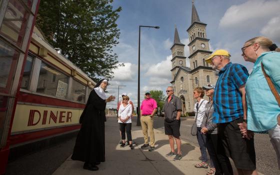 Actress Michelle Berg as Sister Celeste stands in front of the iconic Mickey's Diner restaurant July 8 in downtown St. Paul, Minnesota, as she talks about the history of the city to those taking one of her "True Confessions Gangster" tours.