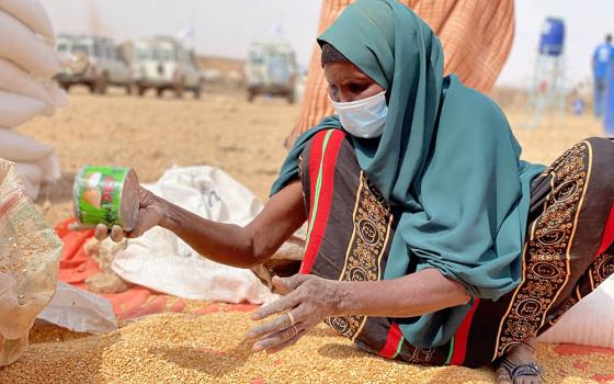 A woman collects grain Jan. 22 at a camp for internally displaced people in Adadle in the Somali Region of Ethiopia. (CNS/Reuters/Courtesy of the World Food Program/Claire Nevill)