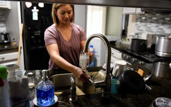 Esperanza Guerrero, 35, fills a glass full with water from her tap in Teviston, California, U.S., October 20, 2021. The town had advised not to drink the water but only use it for washing dishes and washing clothes due to contamination. Approximately 2.2 billion people worldwide (including 46 million Americans) don't have regular access to clean water -- a right Pope Francis outlined in Laudato Si'. (OSV News photo/Stephanie Keith, Reuters)