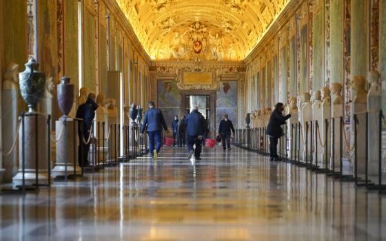 Individual walk down long, ornate passageway. 