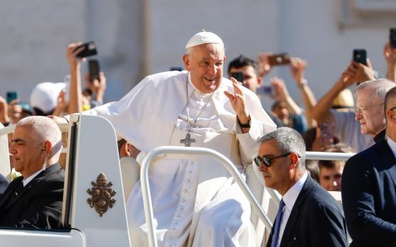 Pope Francis raises hand in greeting from popemobile