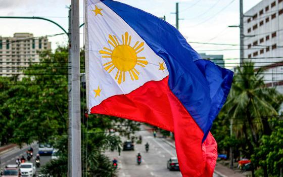 The national flag of the Philippines is seen flying in Manila. (Unsplash/iSawRed)
