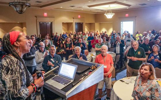 Kim Harris leads attendees in song during her keynote address at the 13th Annual Assembly of the Association of U.S. Catholic Priests June 26 in Lexington, Kentucky. (Paul Leingang)