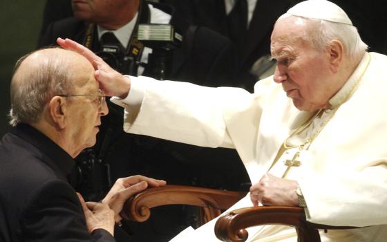 Elderly John Paul II, seated, lays hands on Fr. Maciel's forehead, as he kneels for blessing. 
