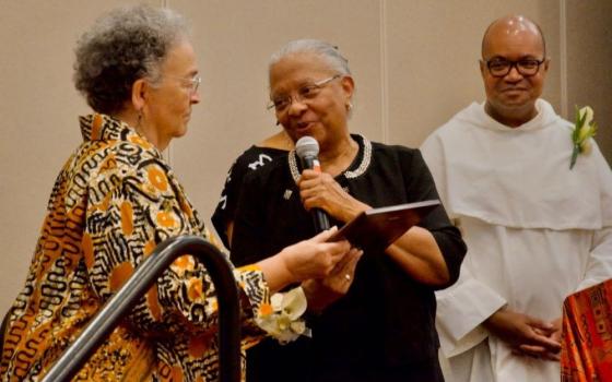 Sr. Eva Marie Lumas, a Sister of Social Service, (left) accepts the National Black Sisters Conference's Harriet Tubman Award from National Black Sisters' Conference President Sr. Addie Lorraine Walker July 29, 2024, in Louisville. Looking on is Fr. Jeffery Ott. (GSR photo/Dan Stockman)