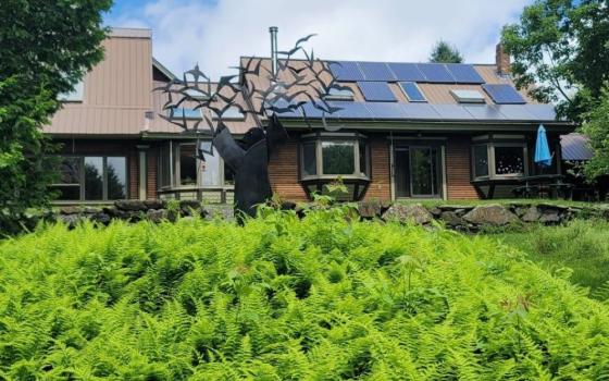 The Sisters of the Earth Community at Green Mountain Monastery and Thomas Berry Sanctuary is in Greensboro, Vt. The 160-acre site includes the monastery's main house, shown from the back. The sculpture, St. Francis and the Birds by artist Frederick Franck, honors Fr. Thomas Berry. (GSR photo/Gail DeGeorge)