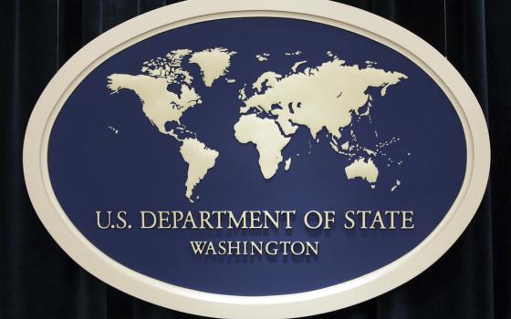 Blue and off-white oval sign with global map, reading "U.S Department of State, Washington."