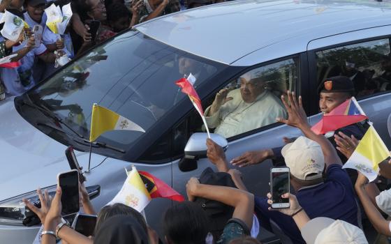 People greet Pope Francis as he travels in a car on way to the Presidential Palace in Dili, East Timor, Monday, Sept. 9, 2024. (AP Photo/Firdia Lisnawati)