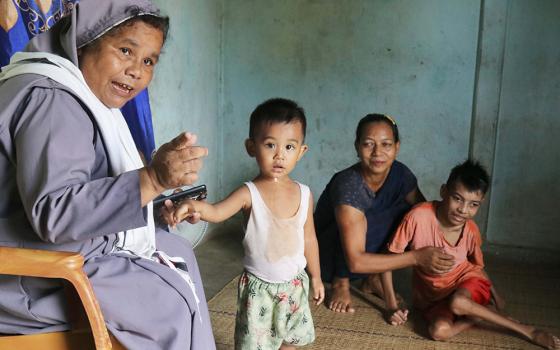 Sr. Elis Lamin, a member of the Visitation Sisters of Don Bosco, talks to a child during a family visit in Nunchhara Punjee in Sylhet Diocese, in northeast Bangladesh. (GSR photo/Stephan Uttom Rozario)