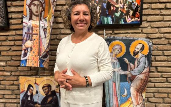 Rosa Bonilla stands near a banner representing St. Phoebe with St. Paul the Apostle at San Lorenzo chapel at the Centro Internazionale Giovanile in Rome Oct. 3.