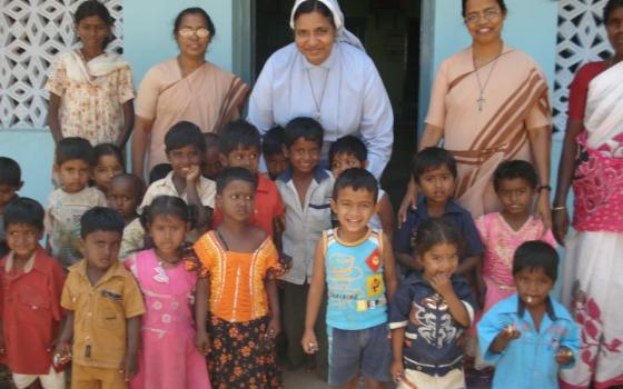 Sr. Maria Goretti (center, back row) and two Missionary Sisters of the Queen of Apostles nuns stand with newly sponsored children from the migrant workers community. Through beneficiaries coordinated by the Dharma Jyothi Social Centre in Mangalore, India, the children will get an education. (Courtesy of  Susai Antony)