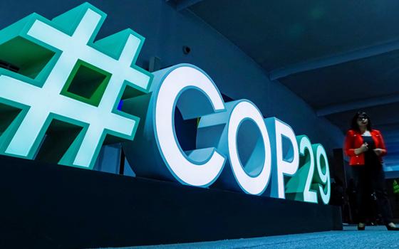 A woman passes by a #COP29 sign during the U.N. climate change conference COP29 in Baku, Azerbaijan, Nov. 11, 2024. (OSV News/Reuters/Maxim Shemetov)