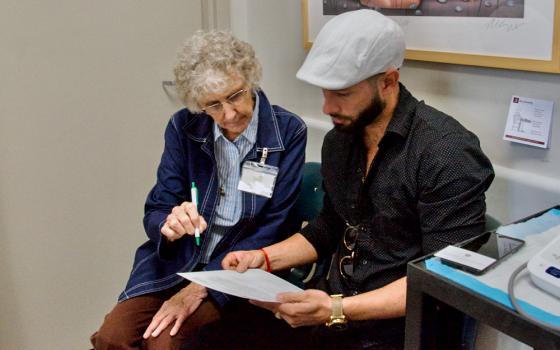 Sr. Kathleen Neely speaks in Spanish to a patient at the Family Community Clinic in Louisville, Kentucky, where she volunteers as a translator. (GSR photo/Dan Stockman)