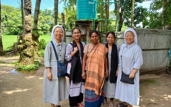 Sister Emma, left, and Sister Agnes, right, are pictured with a family from the Ranikhong Parish who received a tube well from the Sisters of Charity of St. Vincent de Paul, Bangladesh. (Sumon Corraya)