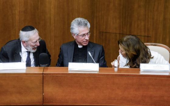 The rabbi on the left, the priest in the center, and the director on the right; the three sit on a panel, facing each other and talking.