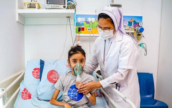 Charity Sr. Bency Paul helps a young patient at Caritas Baby Hospital Bethlehem in the West Bank. (Courtesy of Caritas Baby Hospital/Andreh Ghawaly)