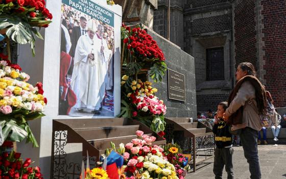 A woman and child stand in front of an image of Pope Francis outside the Basilica of Our Lady of Guadalupe in Mexico City Feb. 23, 2025, after people attended a Mass to pray for the pontiff's health. (OSV News/Reuters/Luis Cortes)