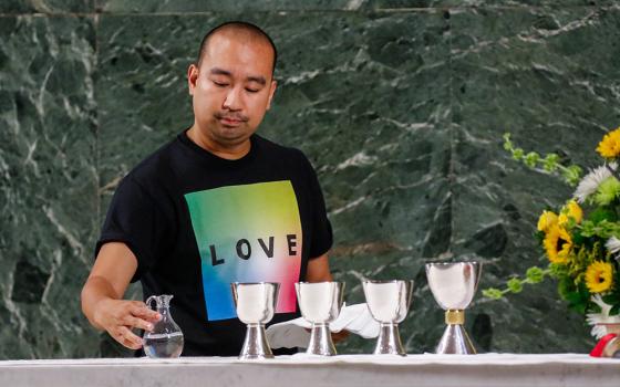 Altar server Angelo Alcasabas prepares the altar during an annual "Pre-Pride Festive Mass" at St. Francis of Assisi Church in New York City on June 29, 2019. (CNS/Gregory A. Shemitz)