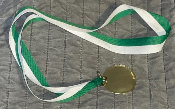 Photo of a medal with a green and white ribbon