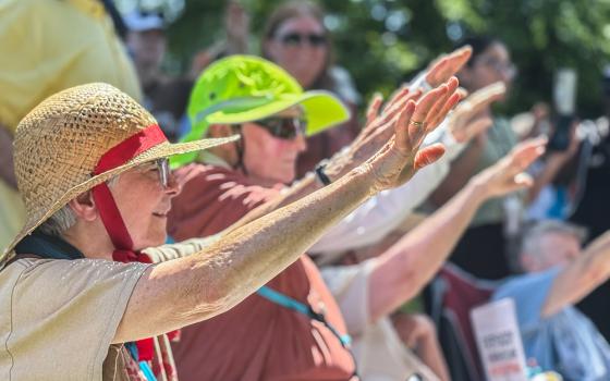 Sisters on the grounds of the U.S. Capitol extend their hands June 25, 2025, as they pray over letters sent to lawmakers opposing a bill that they say will hurt the poor in their communities. A group of about 200 Catholic women religious and their supporters attended the Sisters Speak Out event in Washington, even as temperatures reached almost 100 degrees. (GSR photo/Rhina Guidos)