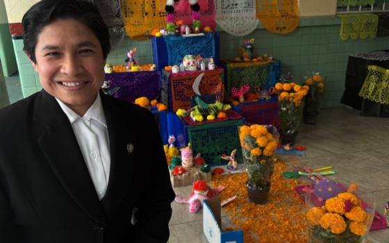 Sr. Brenda Hernández, of the Mexico-based Daughters of Mary Immaculate of Guadalupe, poses in front of a Day of the Dead altar built by students at the Catholic Colegio Tepeyac Mexicano run by her order in Mexico City.