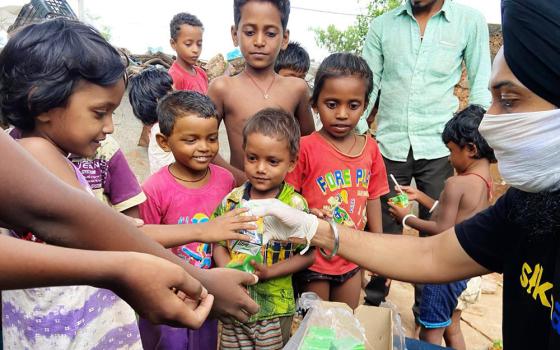 A member of SikhAid shares food with people on the street. (Courtesy of the SikhAid Youth Group)