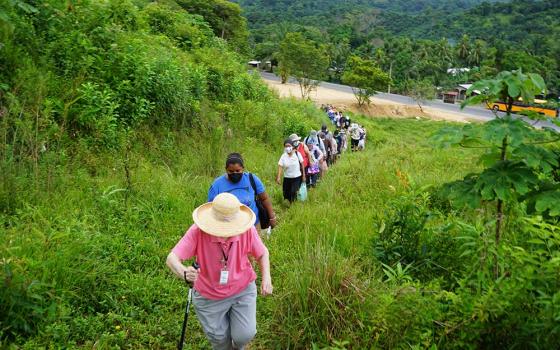 A 24-person delegation to Honduras organized by the SHARE Foundation begins to climb up a hillside to visit with the El Aguacate community.