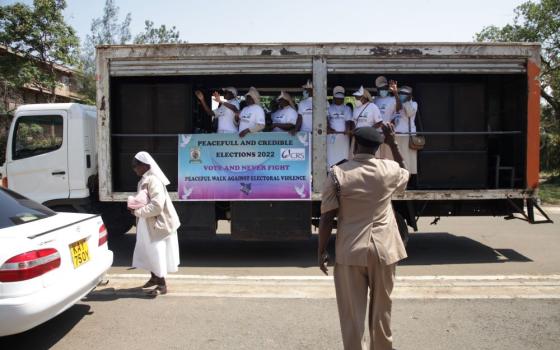 William Lang'at, the assistant county commissioner of Kisumu Central, waves at the peace caravan July 16 at St. Joseph Catholic Church in Milimani, Kisumu, Kenya. (Vincent Aduda)