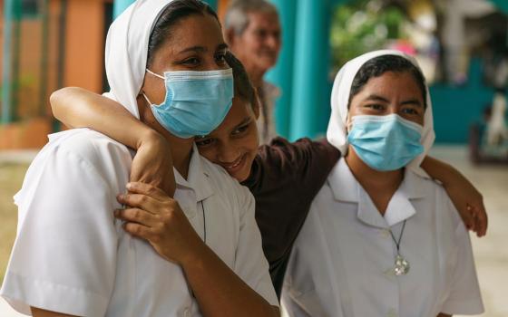 Srs. Jessica Karina Lemus Sánchez and Ana Felipa Olvera Pérez of the Missionaries of Mary Immaculate in Choloma, Honduras, with a young girl whose displaced family is living in the mission's nursery school rooms. (Gregg Brekke)