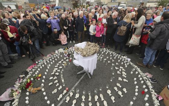 People gather Aug. 26, 2018, to protest at the site of the former Tuam home for unmarried mothers in County Galway, Ireland. (PA via AP/Niall Carson)