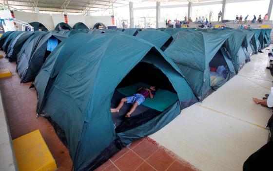 A child sleeps in a tent April 4, 2017, at a shelter for people left homeless after mudslides in Mocoa, Colombia. (CNS/Reuters/Jaime Saldarriaga)