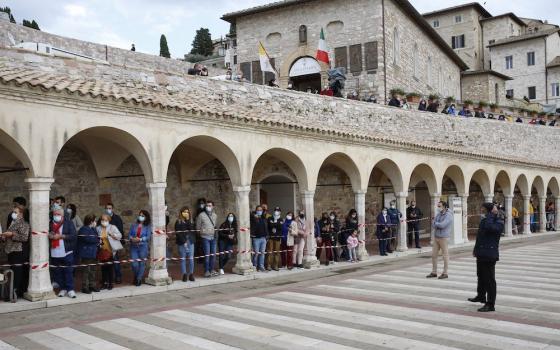 People wait to see Pope Francis outside the Basilica of St. Francis in Assisi, Italy, Oct. 3. The pope celebrated Mass and signed his new encyclical, " 'Fratelli Tutti,' on Fraternity and Social Friendship," in the crypt of the basilica. (CNS/Paul Haring)