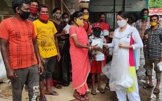 Sujata Jena at a bus stand in Bhubaneswar, meeting some workers of Kalahandi, Odisha, in India, who returned from Tamil Nadu, some 2,000 kilometers (1,240 miles) away from Odisha. She shared some food packs with them as they didn't have money to buy food 