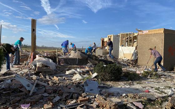 Volunteers with the Sisters of Charity of Nazareth sort through and clear debris from a home severely damaged by tornadoes in Campbellsville, Kentucky, accompanied by the surviving family and friends. (Courtesy of Ellen Sprigg)