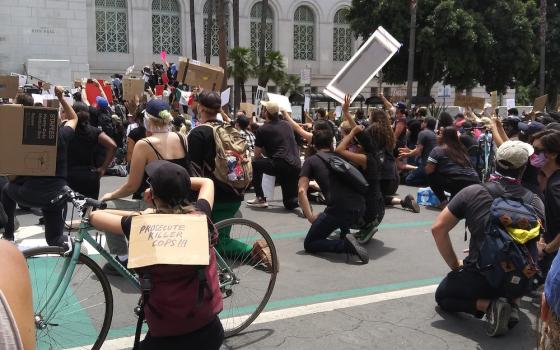 Demonstrators supporting George Floyd and protesting police brutality and killings, especially against Black people, take a knee at City Hall in Los Angeles, for "Blackout Tuesday," June 2 (Wikimedia Commons/Kriddl)