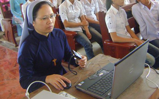 Daughters of Mary Immaculate Sr. Teresa Truong Thi Thao Nhi teaches health to young Catholics in Cau Hai Parish in Hue in April. (Peter Nguyen)