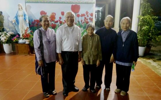 Jesuit Fr. Thomas Vu Quang Trung and Sisters of Providence of Tay Nguyen, Vietnam, pose for a photo at their convent. (Joachim Pham)