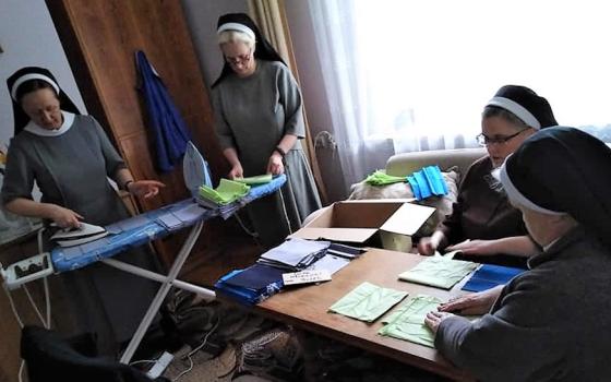 Sisters in Poland in a room making masks