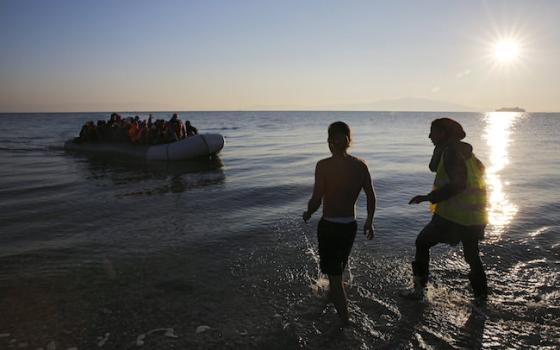 Volunteers approach a raft overcrowded with migrants and refugees on the Greek island of Lesbos Nov. 17. (CNS photo/Yannis Behrakis, Reuters) 