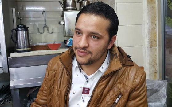 Mohammad Rostom, 23, in the small restaurant in Amman, Jordan, where some of his relatives work. They are all originally from Syria. (GSR/Chris Herlinger)