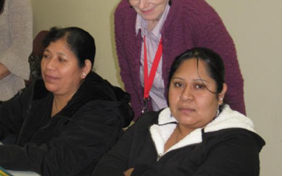 Sr. Mary Beth Moore, standing, coaches women in a literacy program 