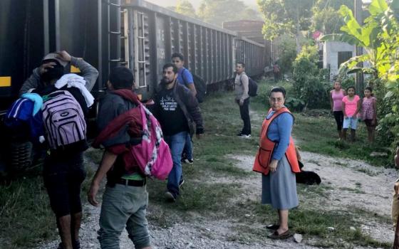 Franciscan Missionaries of Mary Sr. Carmen Balbuena is seen with migrants next to "La Bestia" in Mexico. (Courtesy of the Franciscan Missionaries of Mary)