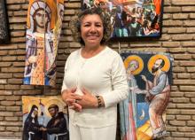 Rosa Bonilla stands near a banner representing St. Phoebe with St. Paul the Apostle at San Lorenzo chapel at the Centro Internazionale Giovanile in Rome Oct. 3.